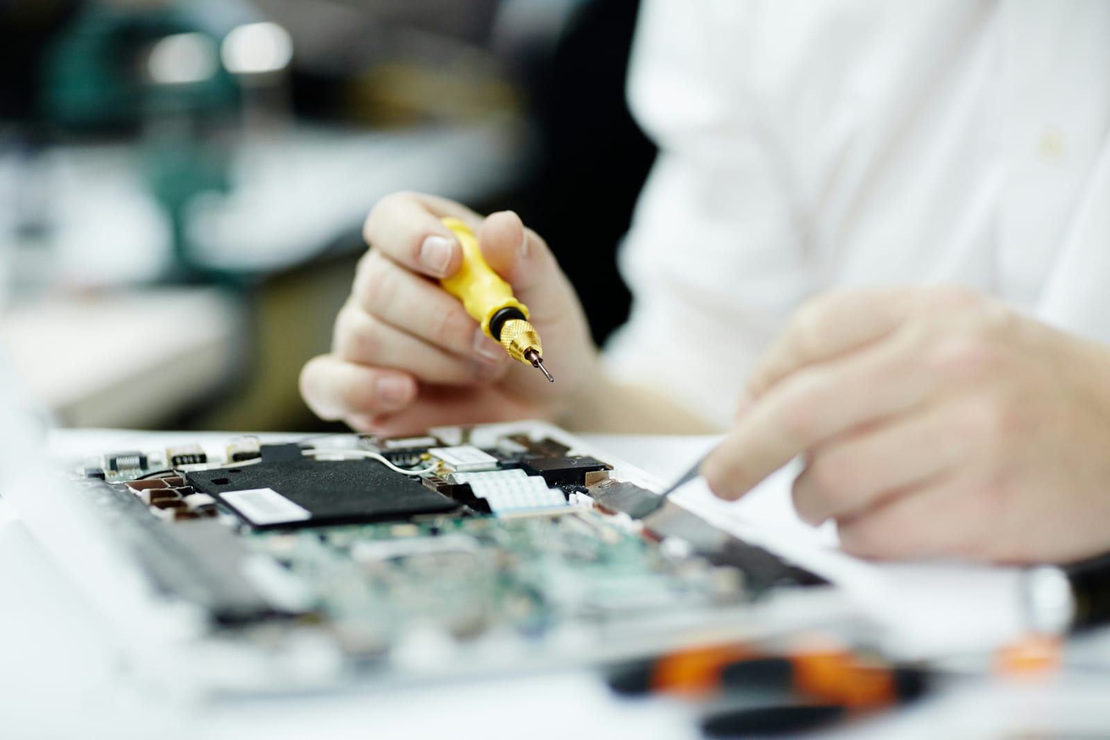 Technician working on a board with written notes to hand