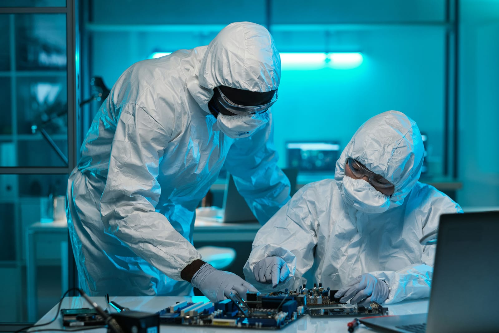 Engineers working on a board in a cleanroom