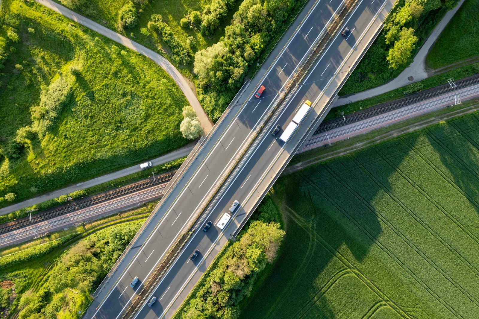 Aerial view of freight vehicles on a highway crossing open country