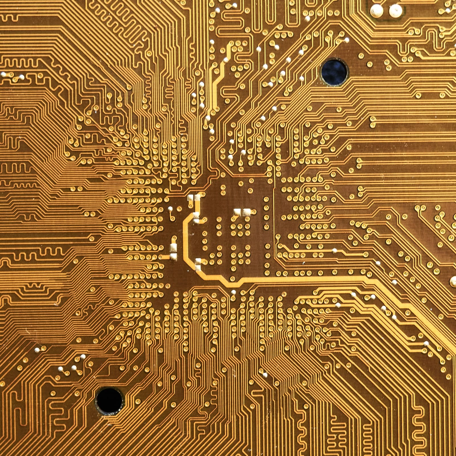 Macro photograph of gold PCB traces and pads